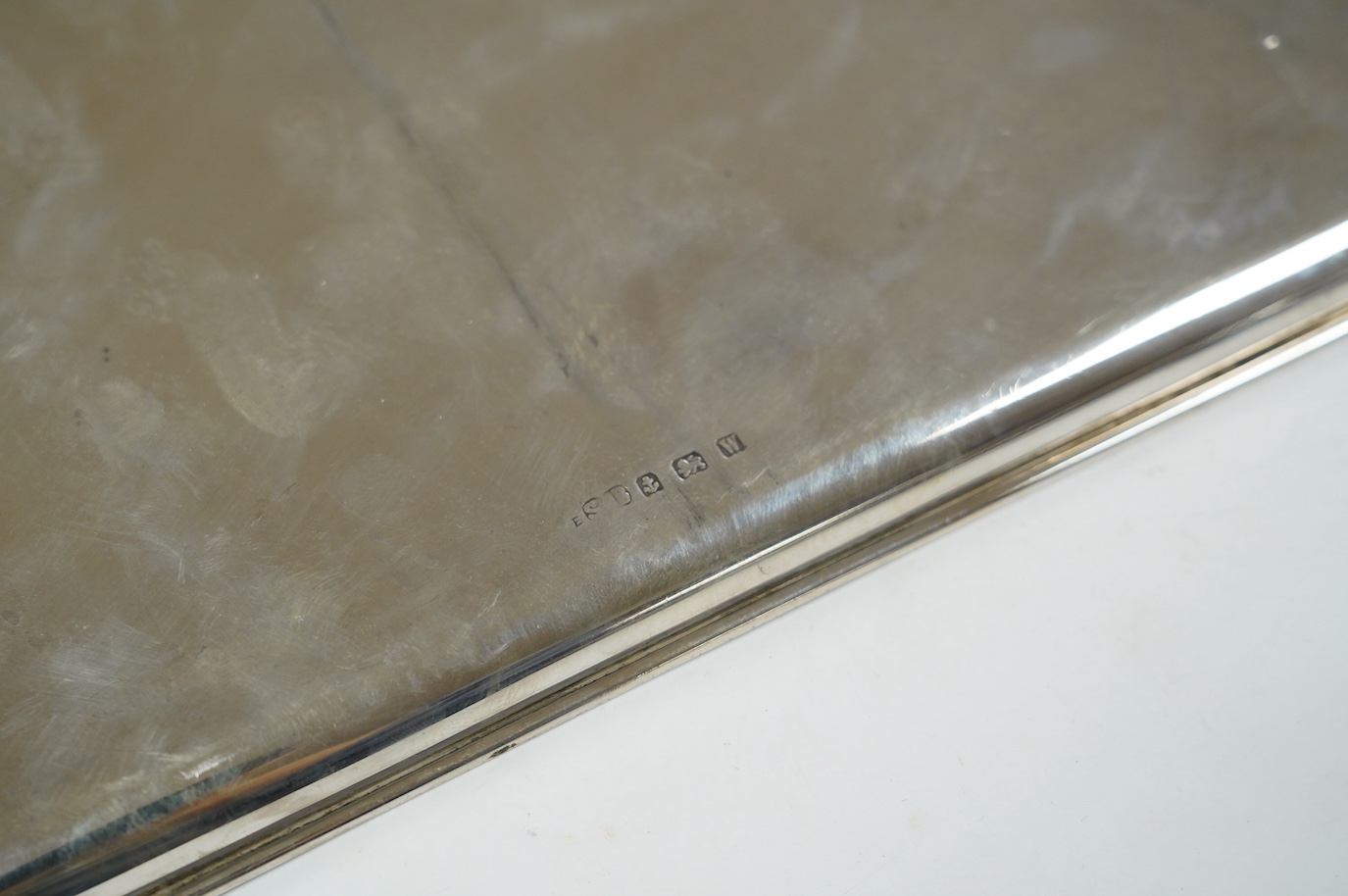 A George V rectangular silver stand, engraved with signatures and presentation inscription, on claw and ball feet, Charles Boyton & Son Ltd, London, 1916, 20.7cm, together with a silver dressing table tray, 20.6oz. Condi